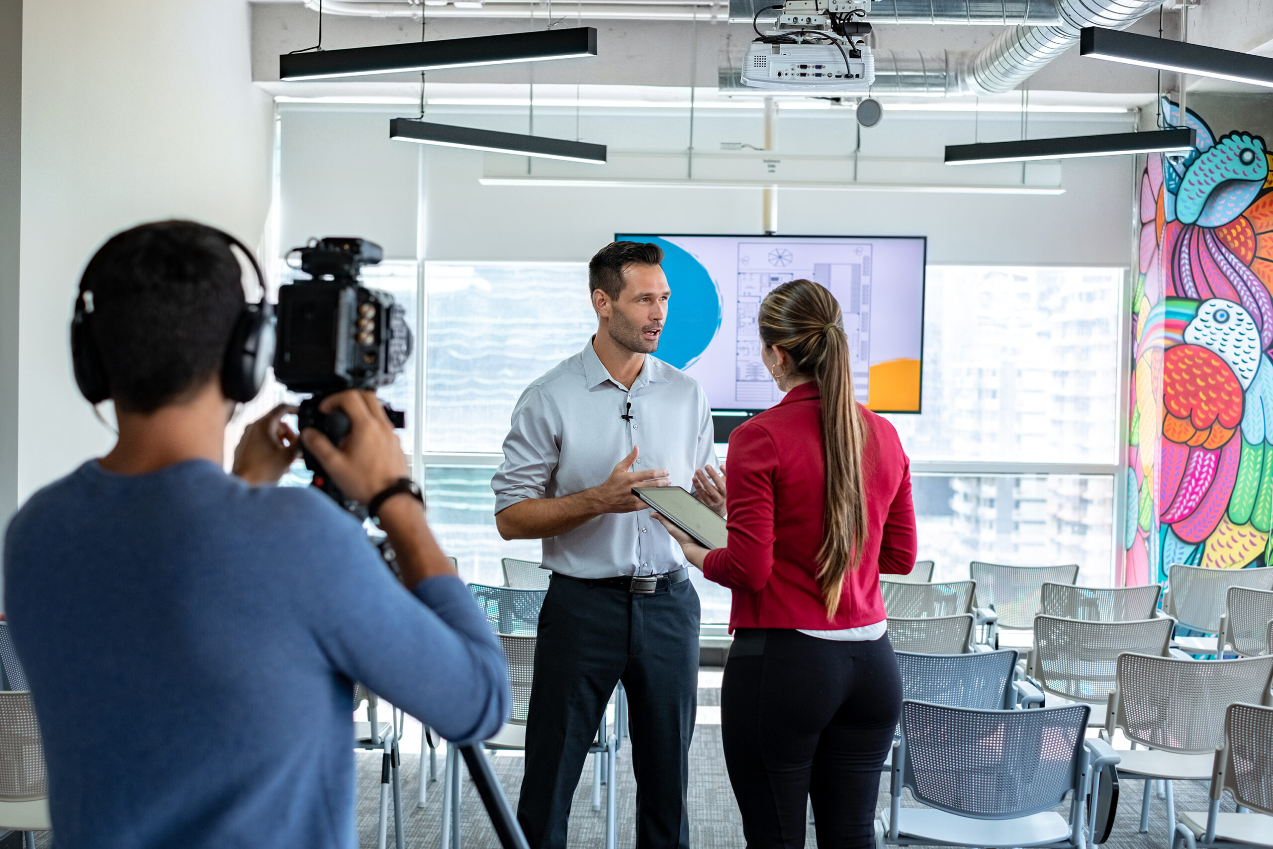 Female filmmaker interviewing male businessman for video testimonial